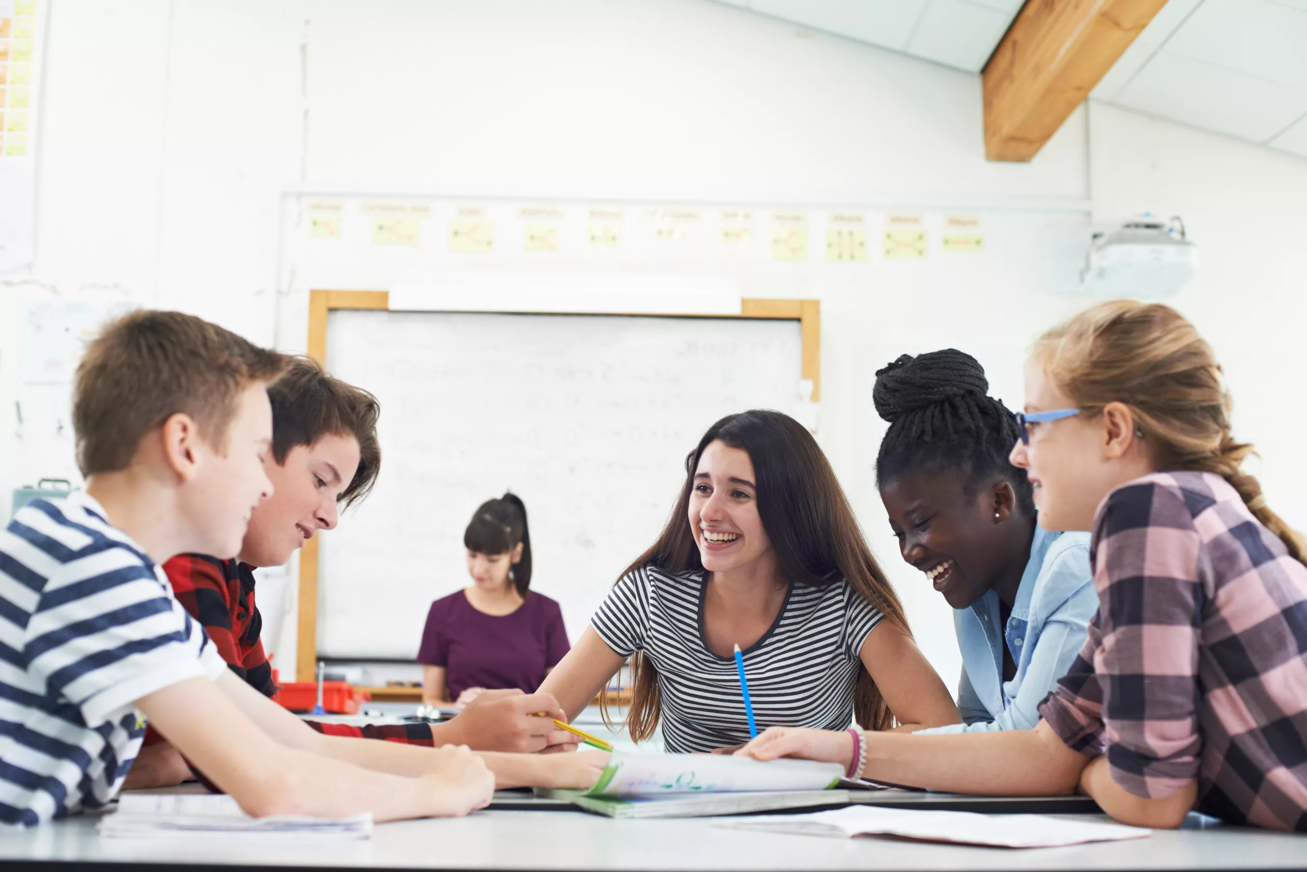 Group Of Teenage Students Collaborating On Project In Classroom